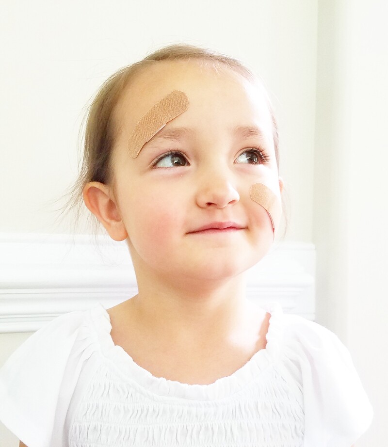 Young girl wearing a band-aid. The band-aid was first created in 1920