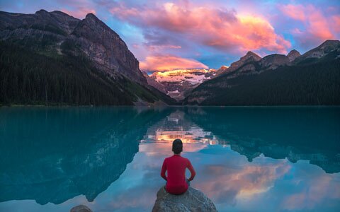 Un hombre observa nubes matutinas sobre el hermoso Lago Louise en el Parque Nacional Banff, en Canadá.
