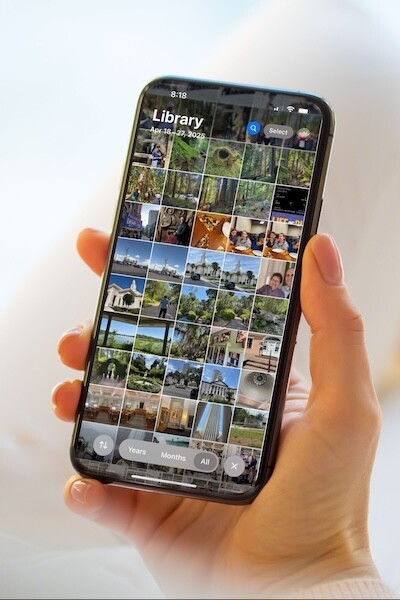 A hand holding a smartphone with a collection of images