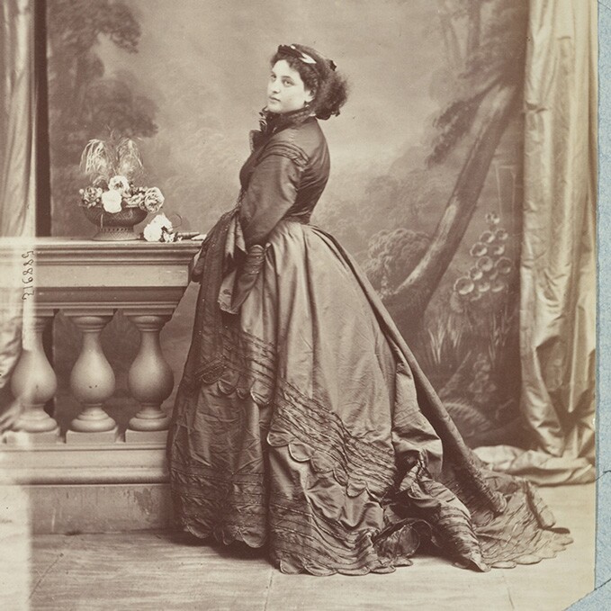 An example of a woman from the 1860s wearing a dress with a reduced-front crinoline underneath.
