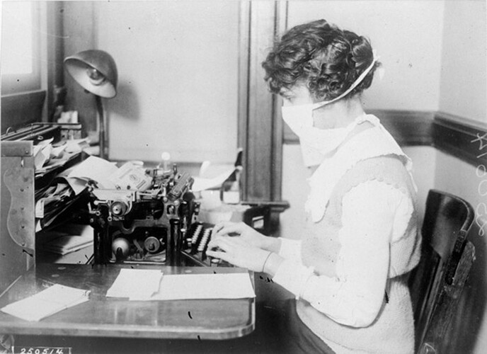 a woman wears a mask while she works during the 1918 Spanish Flu.