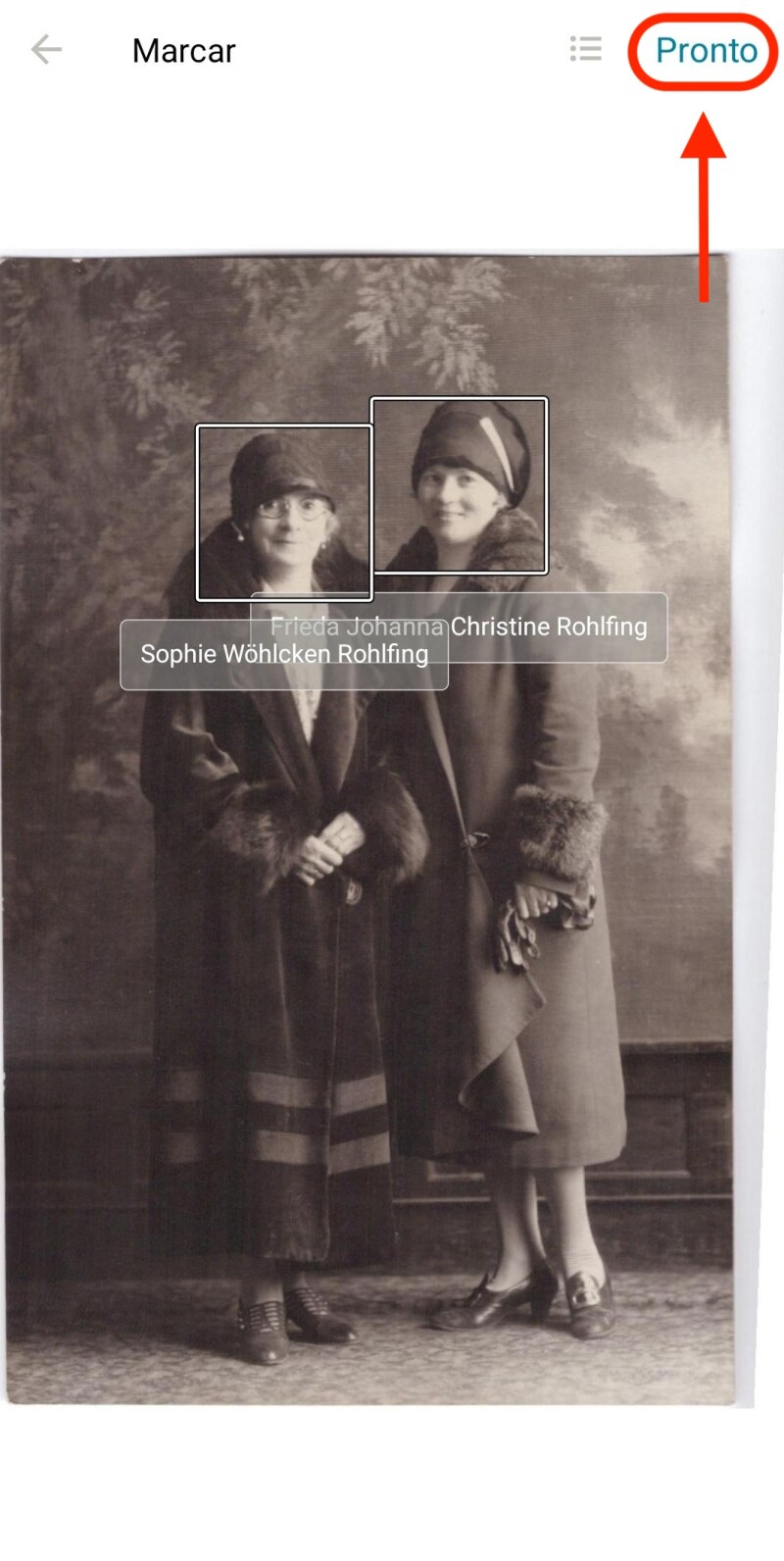 Uma foto de duas mulheres juntas, como visto no visualizador de recordação do FamilySearch. Há círculos ao redor de cada rosto com seus nomes embaixo. Um oval vermelho está ao redor de um botão na parte inferior da tela que diz "Concluído".