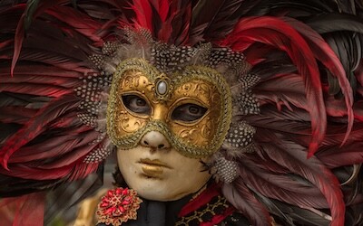 En person på karnevalet i Venezia kledd i kostyme og iført en Columbina-maske