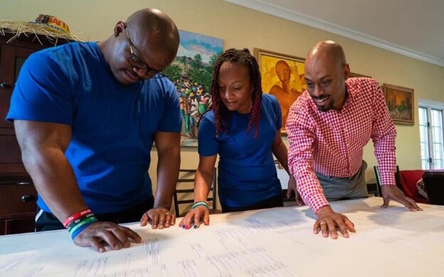 Andre with cousins examining their family tree on the Relative Race Season 6 premiere