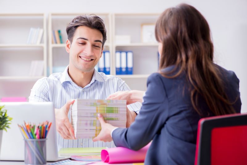 A man gives a woman informational pamphlets.