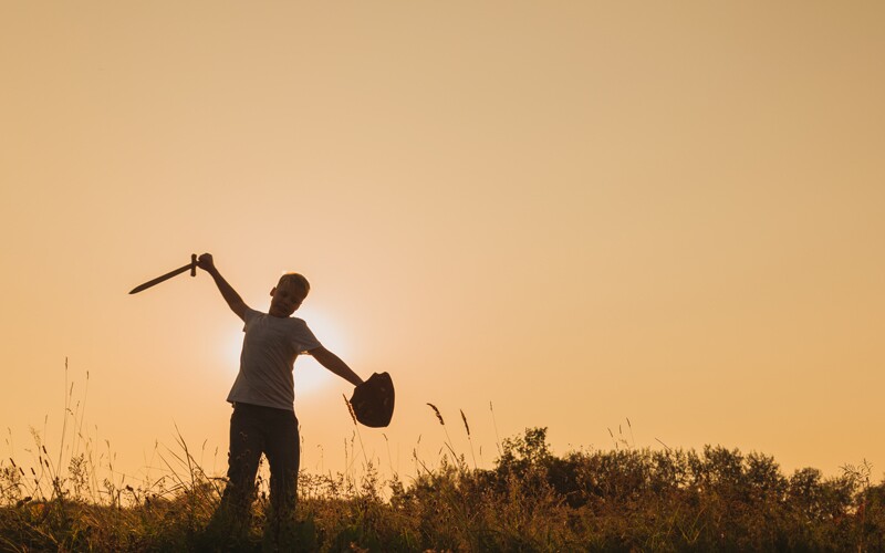 an english boy plays with a toy sword and shield 