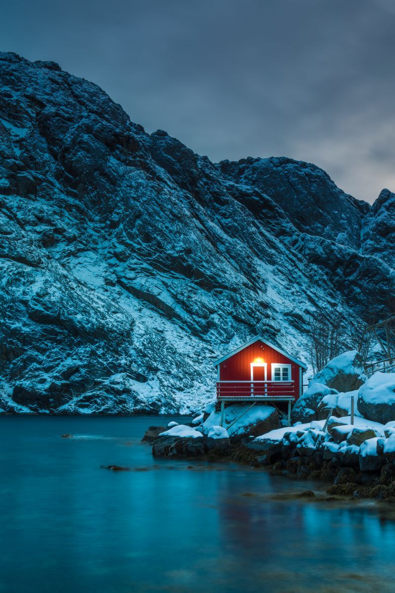 A red house on the edge of a fjord in Norway