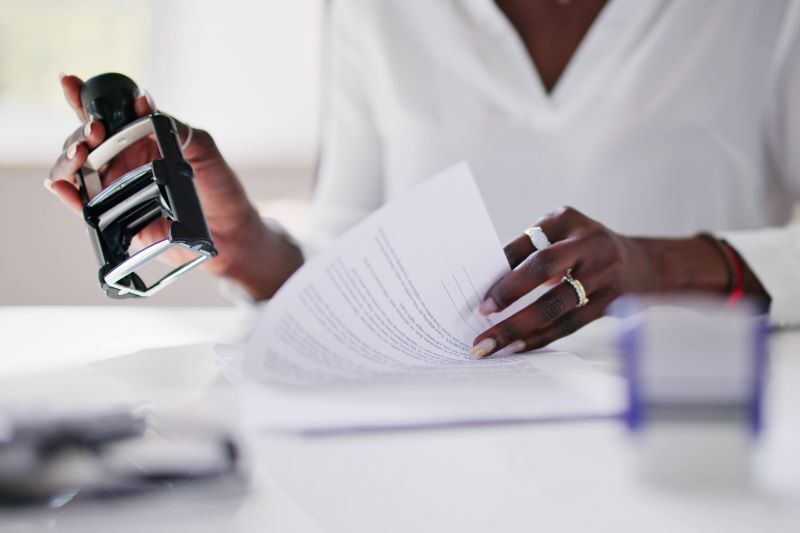 A woman stamps an official document.