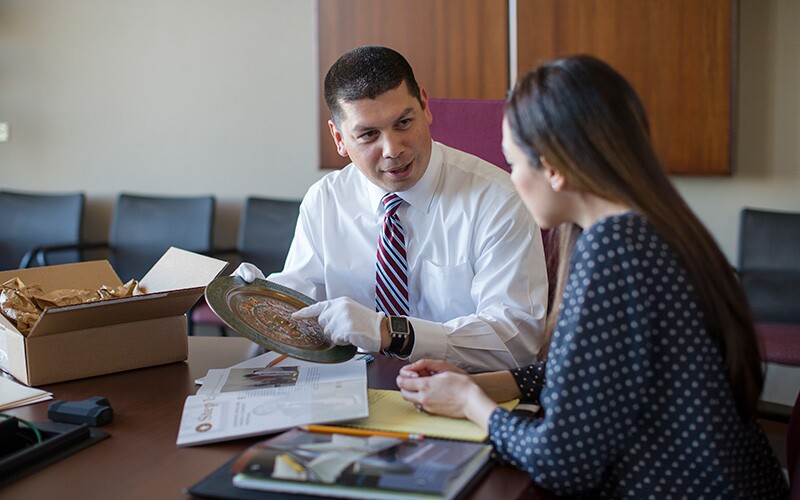A staff member helping someone to find records at the Church History Library.
