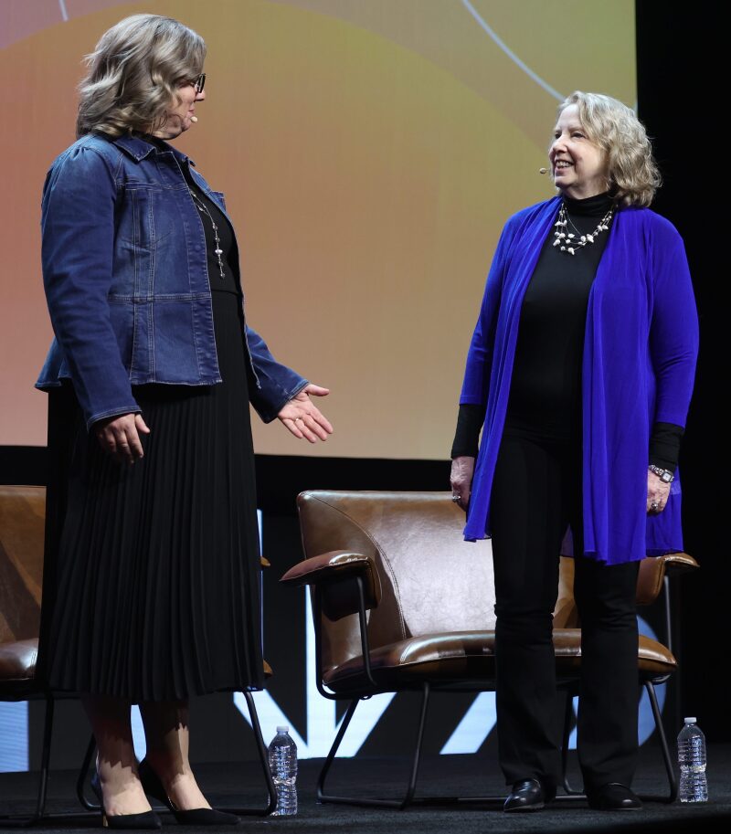 Dr. Robyn Fivush en dr. Jody Koenig Kellas tegenover elkaar op het podium van RootsTech.