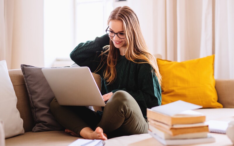an english girl reads on her laptop 