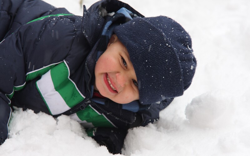 a boy plays in the snow, a weather that would be considered brass monkeys.