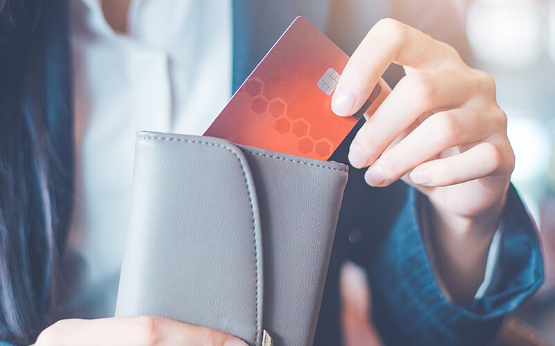 A woman pulling out a credit card