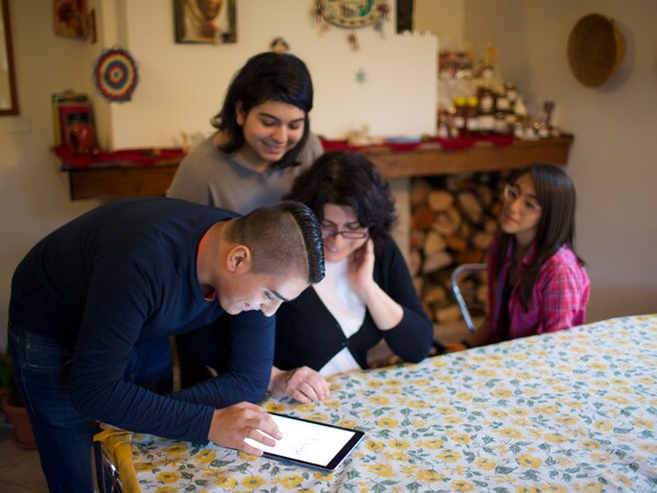Uma família reuniu-se em torno de uma mesa para trabalhar em conjunto sobre a sua história familiar.
