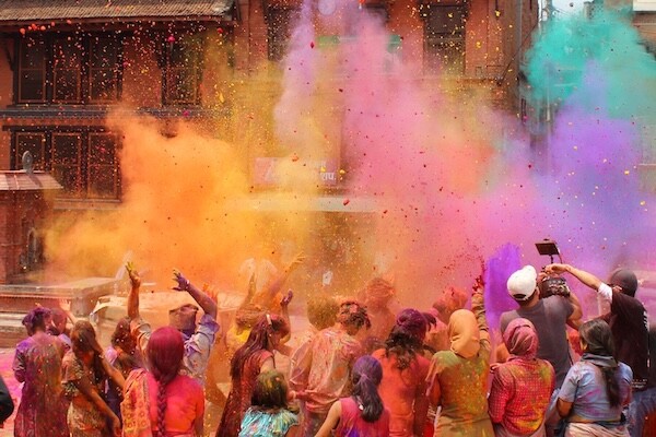 A group of people throwing colored powder (gulal) at a Holi celebration