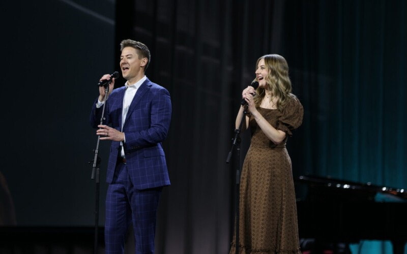 Mat and Savanna Shaw singing on the main stage of RootsTech 2025