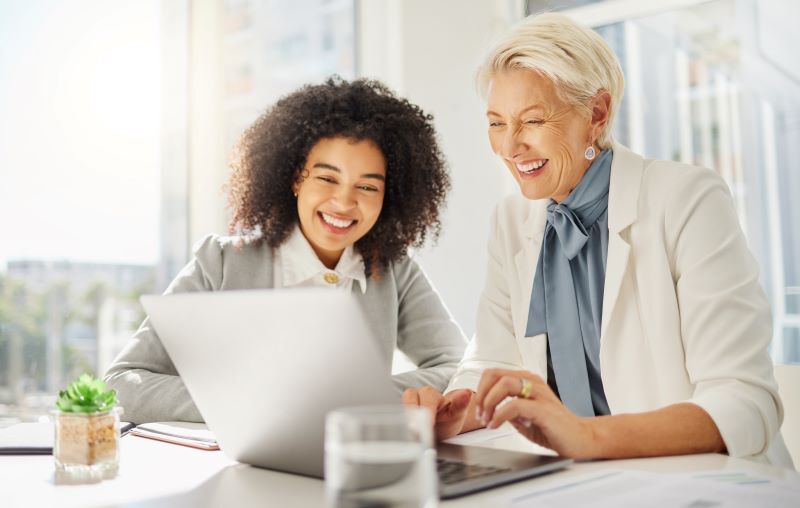 An older woman mentors a younger woman.
