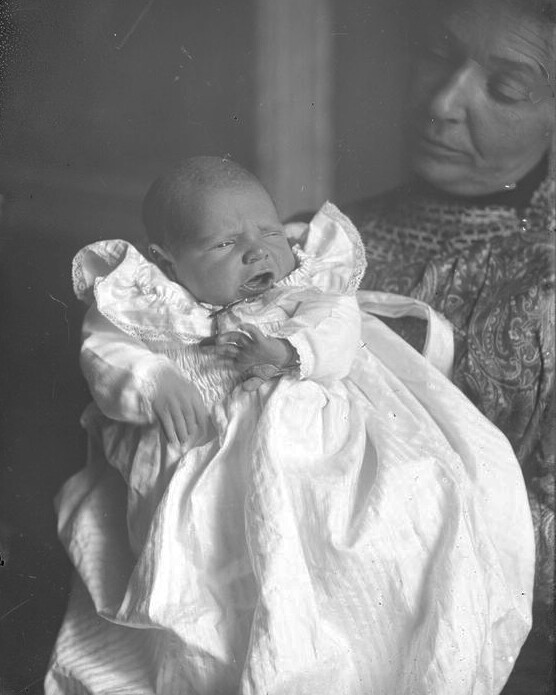 An infant in a white dress. Photo likely taken between 1858 and 1907. Some enhancement added.