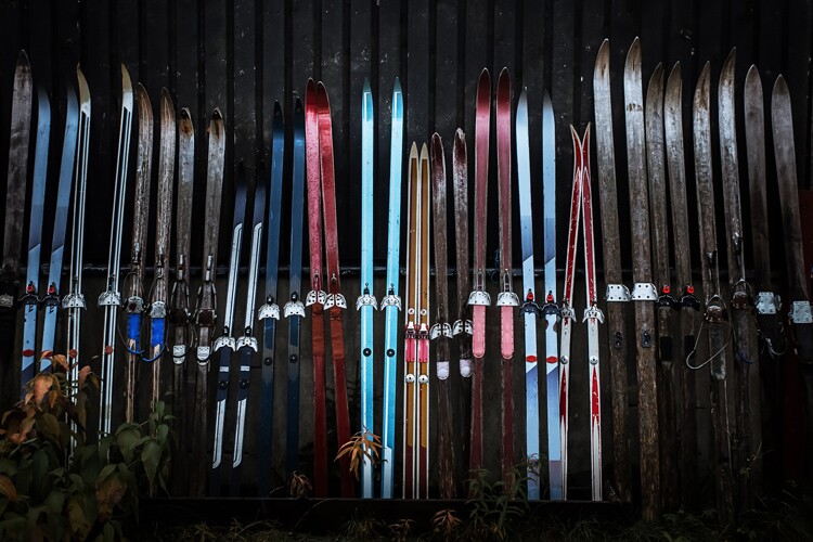 nordic skis lined up on a wall