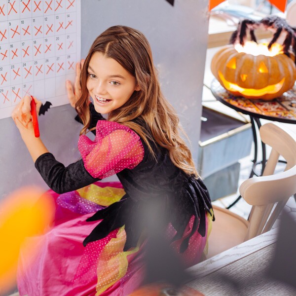 Young girl in a holiday costume, excited to celebrate the Halloween holiday.