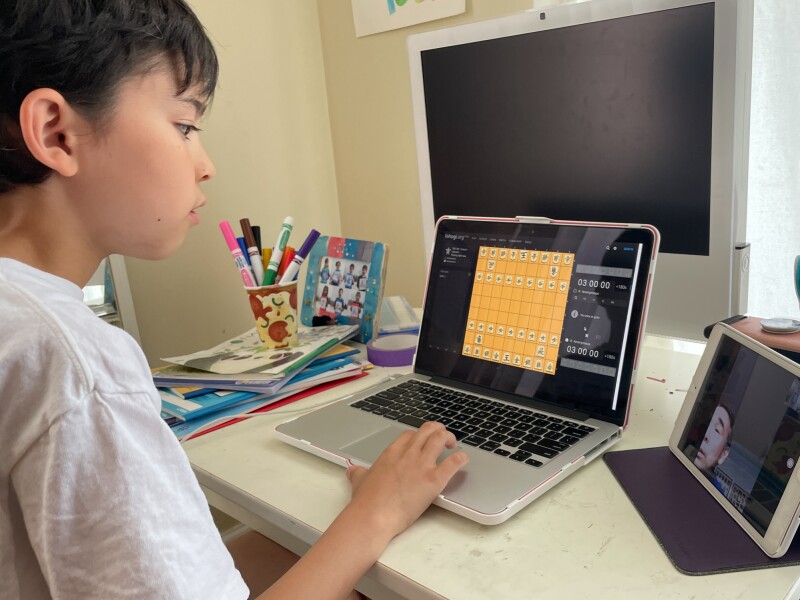 Petit-fils joue aux échecs avec son grand-père. Garder le contact sur Zoom.