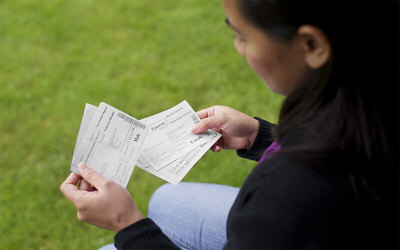 a woman holds temple ordinance cards.