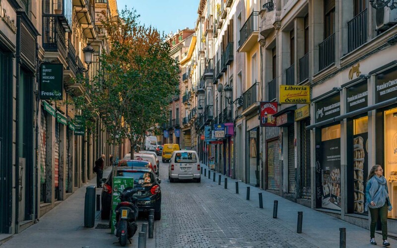 Una strada di Madrid, in Spagna, fiancheggiata da auto e biciclette