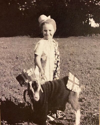 A little girl and her goat dressed up for a Dominion Day parade