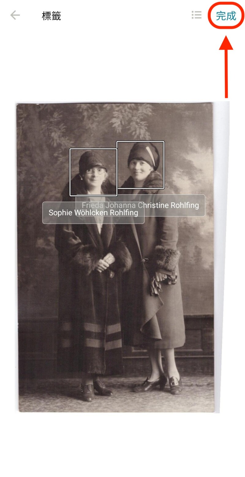 在 FamilySearch 回憶檢視中,一張兩位婦女站在一起的相片。每個臉孔都有圓圈包圍著,下方有他們的名字。畫面下方有一個紅色橢圓形包圍著按鈕,按鈕上面寫著「完成」。