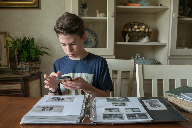 a boy takes photos of his family photos.