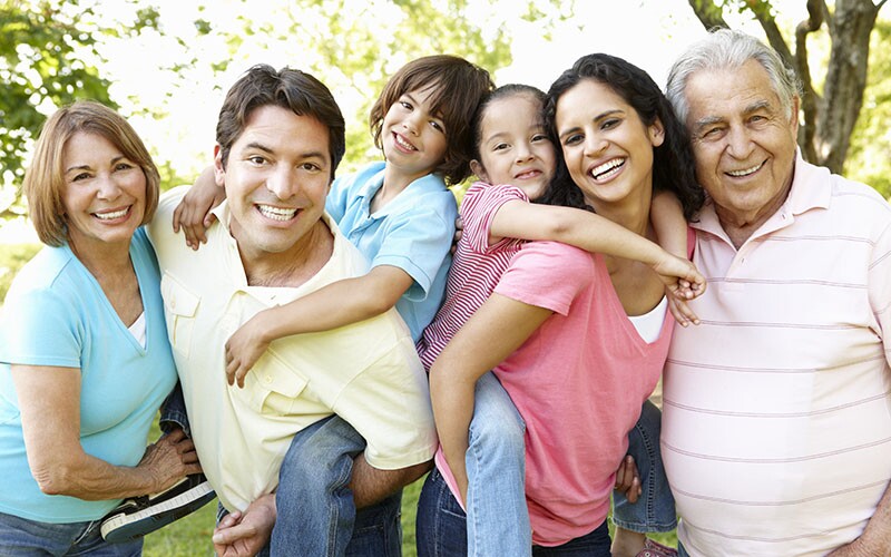 Multi Generation Hispanic Family Standing In Park