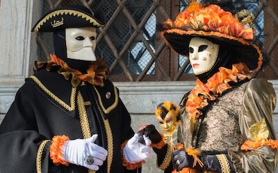 En person på karnevalet i Venezia kledd i kostyme og iført en Bauta-maske