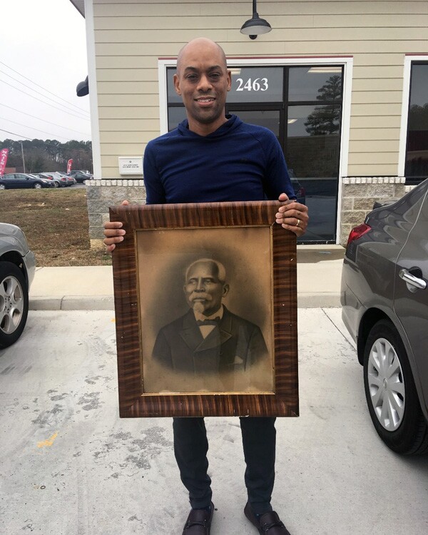 Andre Kearns with original crayon portrait of Exum White, an African American ancestor