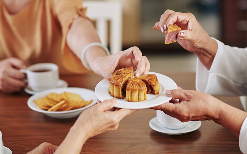 Three women share mooncakes