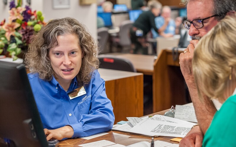 A Family History Library assistant helps patrons
