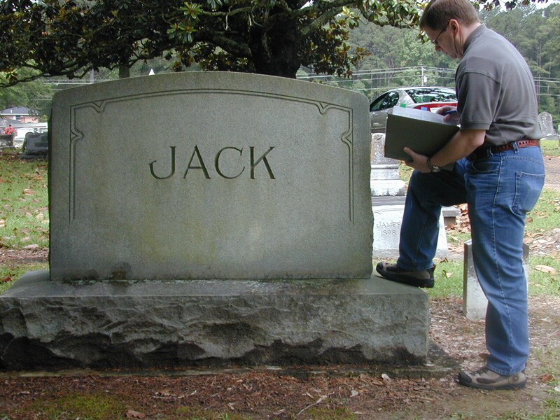 David Rencher at a grave site with a large stone marker.