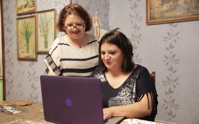Two women looking at the screen of a laptop computer
