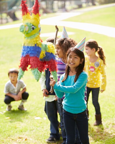 Children breaking pinatas