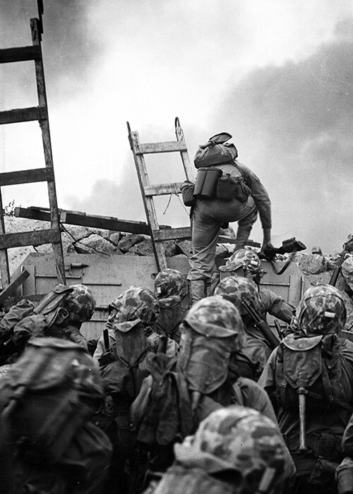 Marines climbing over a wall in the Korean War