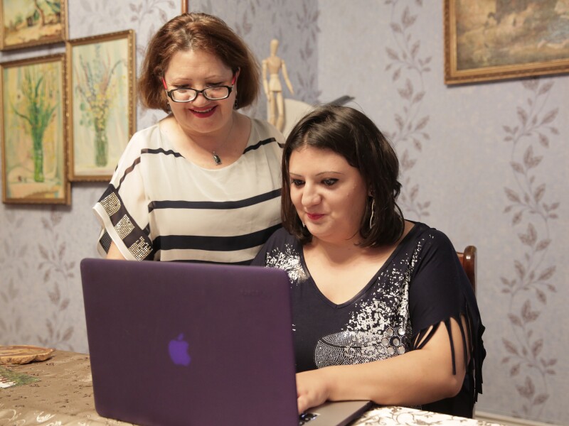 Two women looking at the screen of a laptop computer