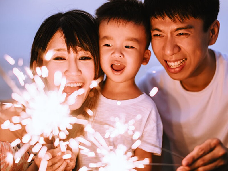 ครอบครัวที่มีความสุขฉลองปีใหม่กับดอกไม้ไฟ