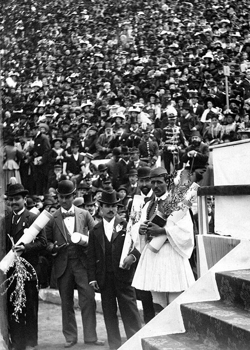 Spyridon Louis holding a trophy after winning the first modern Olympics marathon.