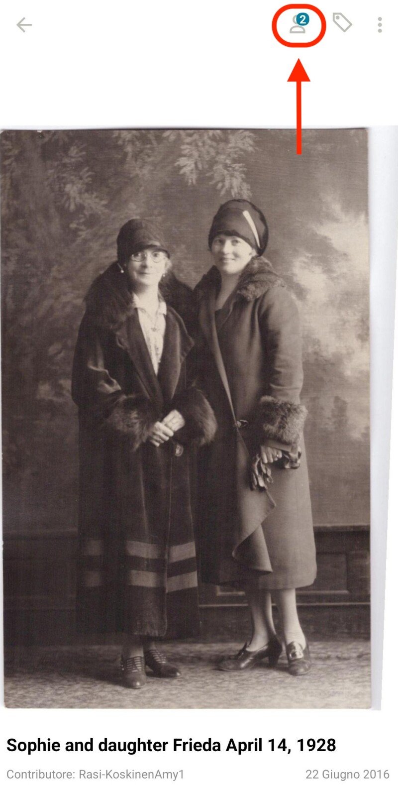 Una foto di due donne in piedi insieme vista nel visualizzatore di ricordi di FamilySearch. Un ovale rosso circonda un'icona a forma di persona nell'angolo con una freccia rivolta verso di essa.
