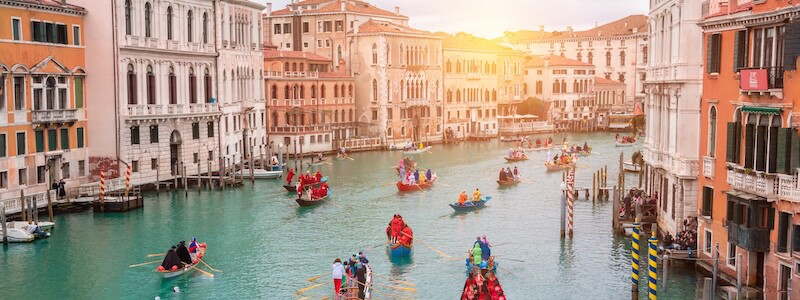 En parade av gondoler på en elv i Venezia