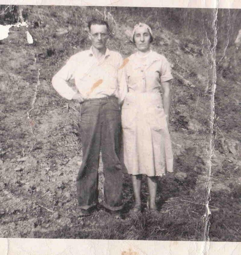 Et svart-hvitt bilde av et par som står utendørs, før MyHeritage Repair har blitt brukt. Fotografiet har noe fysisk slitasje og bretter.