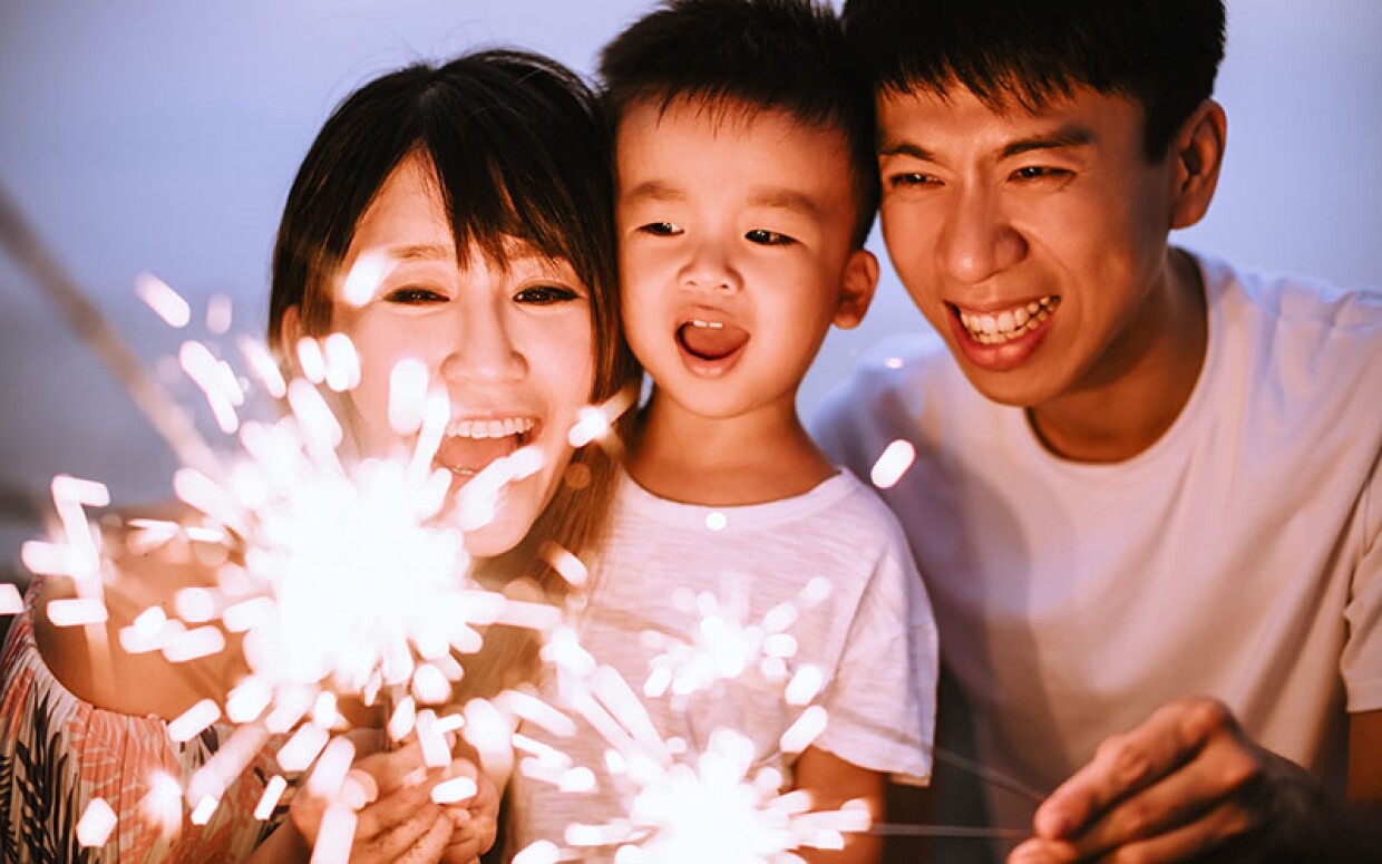 happy family celebrating new year with sparklers
