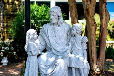 a statue of Jesus Christ with young children