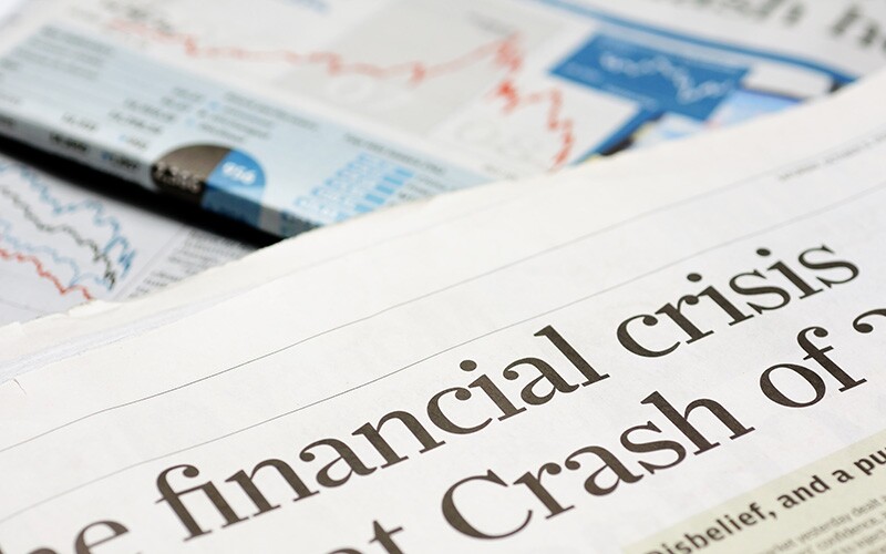 A newspaper with a headline that says "financial crisis."