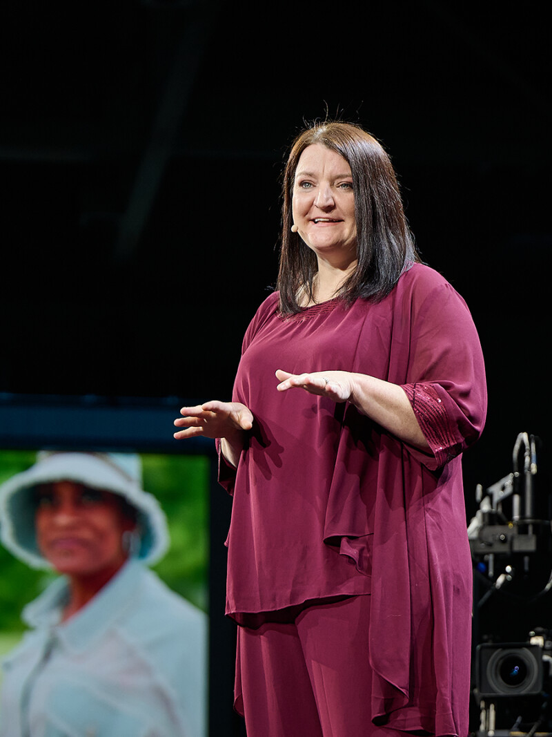 Lindsay Fulton presents at the RootsTech 2025 Impact Forum with a blurred image of Lisa Shepperson in the background.