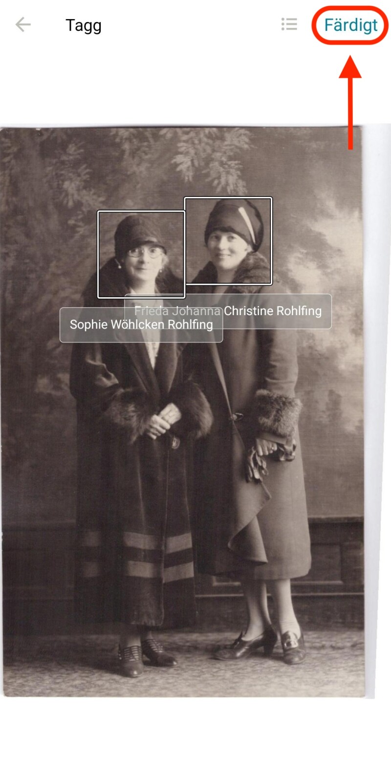 Ett foto av två kvinnor som står tillsammans, i FamilySearchs minnesvisare. Det finns cirklar runt varje ansikte med deras namn under. En röd oval är runt en knapp längst ner på skärmen där det står ”Klar”.